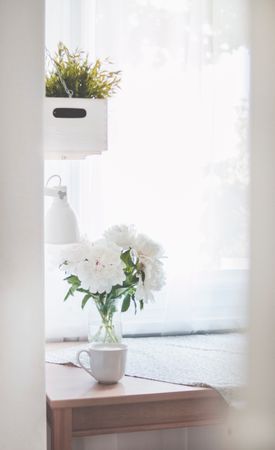 White Peonies In Clear Glass Vase Centerpiece Near A White Ceramic Mug Closeup Photography Photo