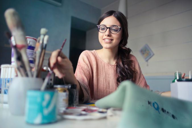 Woman In Brown Long-sleeved Shirt Wearing Eyeglasses Holding Paint Brush Photo
