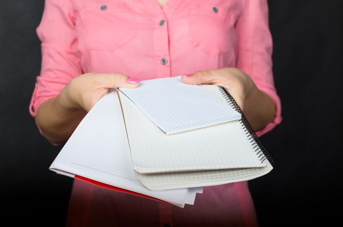 Woman In Pink Shirt Holding Books And Papers Photo
