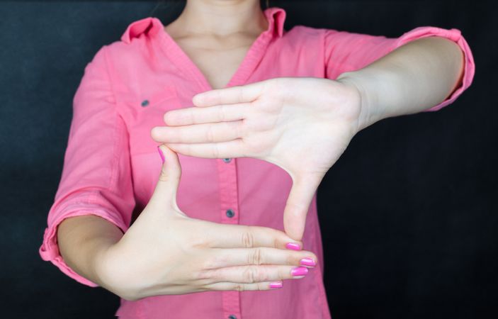 Woman In Pink Shirt Making Frame By Her Hands Photo