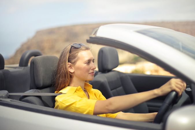 Woman In Yellow Shirt Driving A Silver Car Photo