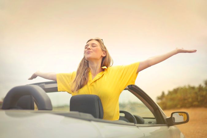Woman Sitting On Car Under Gray Sky Photo