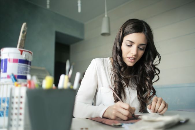 Woman Sitting While Holding Pen Photo
