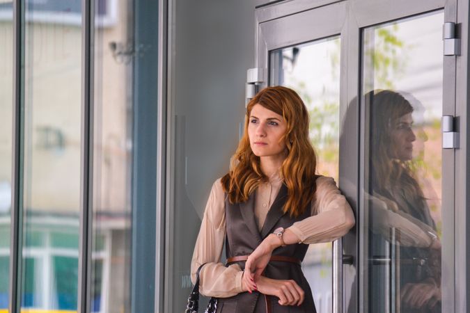 Woman Standing Near Clear Glass Gray Framed Door Panel Photo