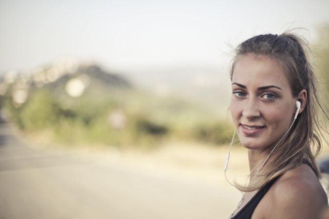 Woman Wearing Black Tank Top And White Earbuds Photo