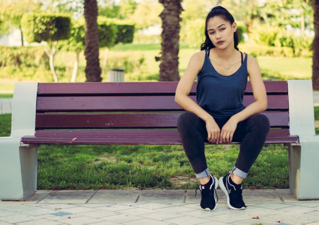 Young Girl Seating On Bench In Garden Photo