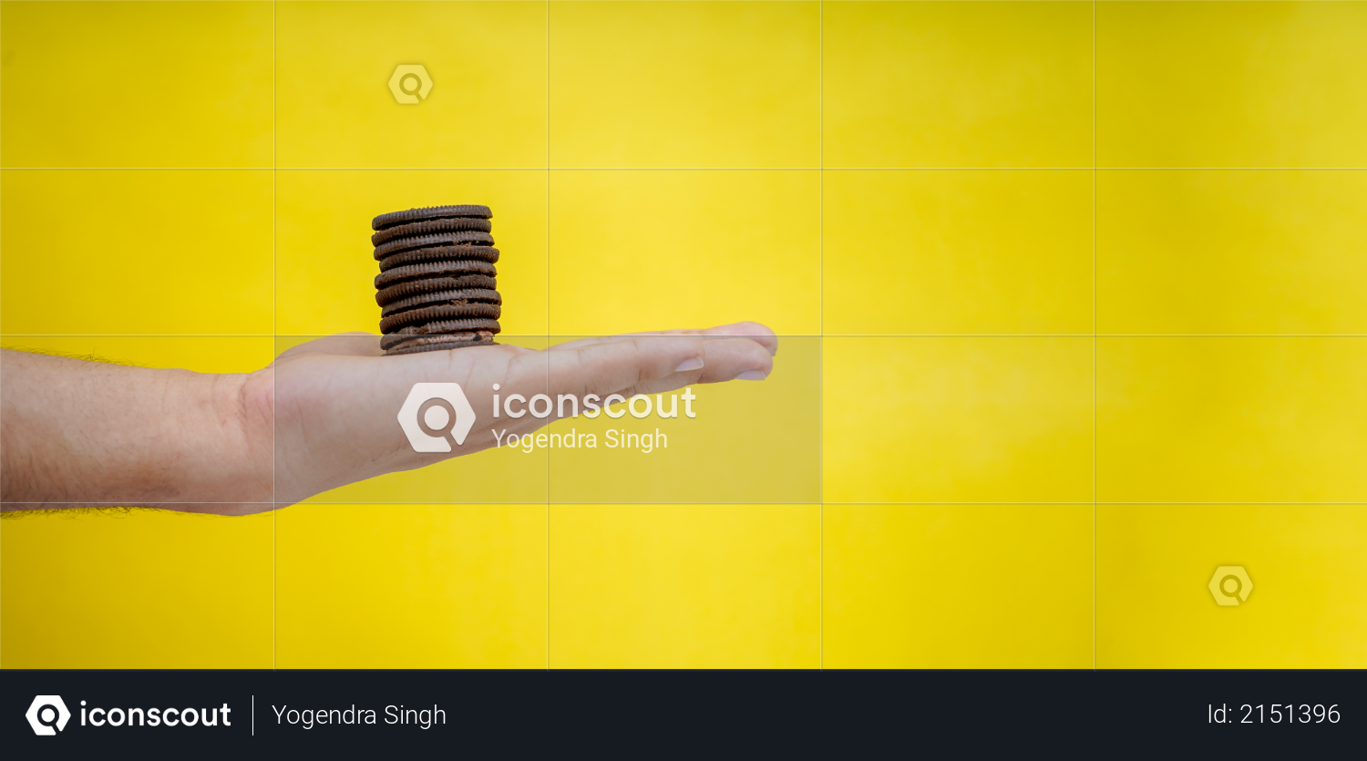 Hands holding chocolate biscuits on a yellow background with copy space Photo