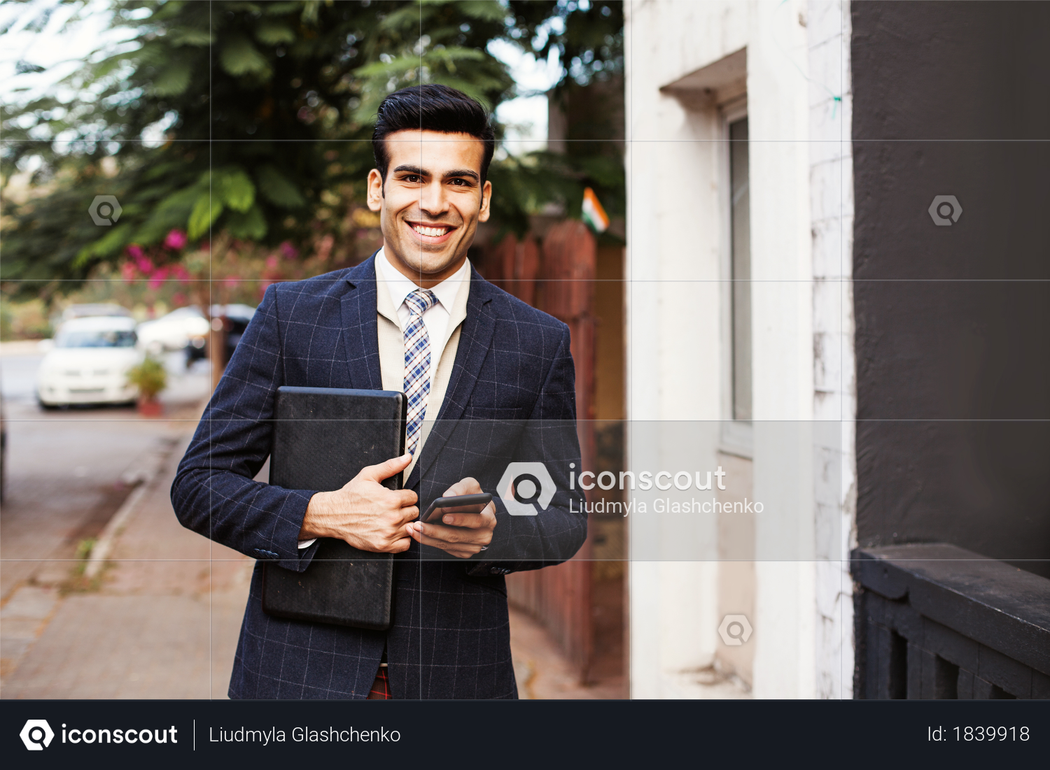 Indian businessman holding mobile and tablet on Indian street road Photo