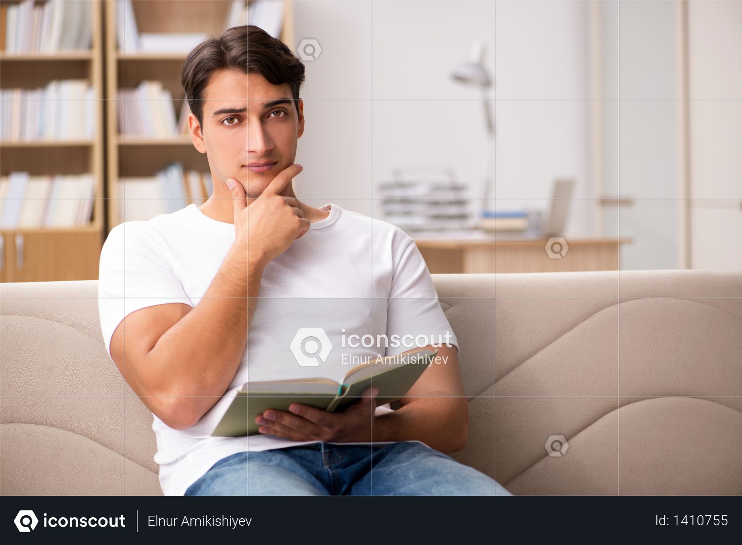Man reading book sitting in couch sofa Photo