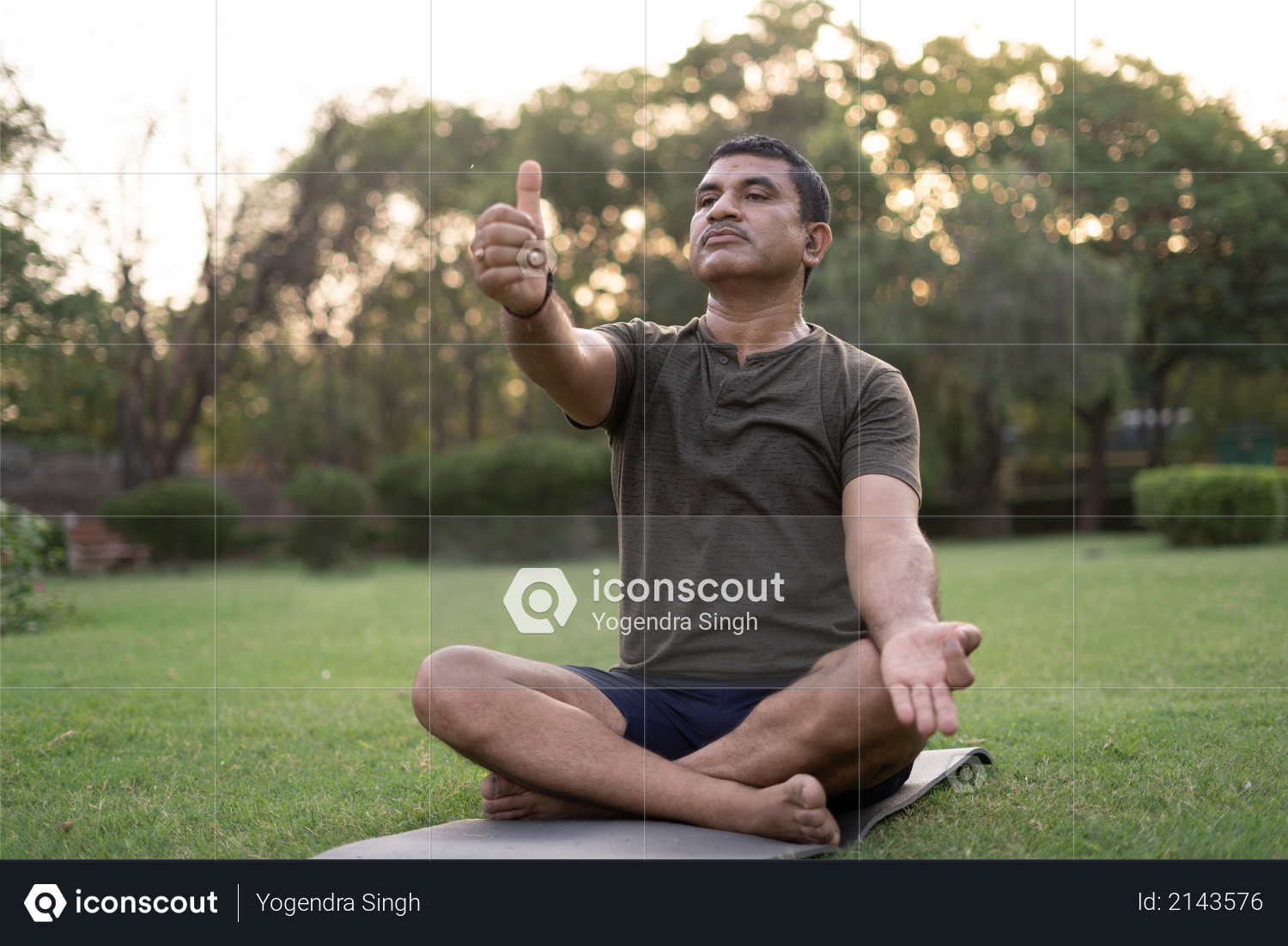 Mid-aged Man doing yoga in a park covered with trees on International Yoga Day Photo