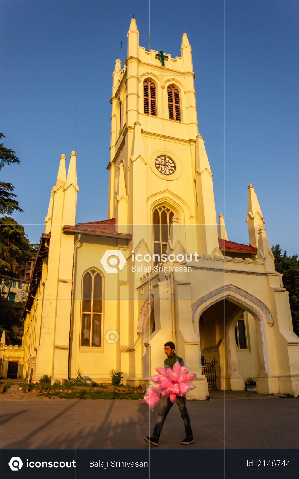Shimla, Himachal Pradesh, India - May 2012: A street vendor walks past the British colonial era neo-Gothic architecture of Christ Church, one of the oldest surviving churches in North India. Photo