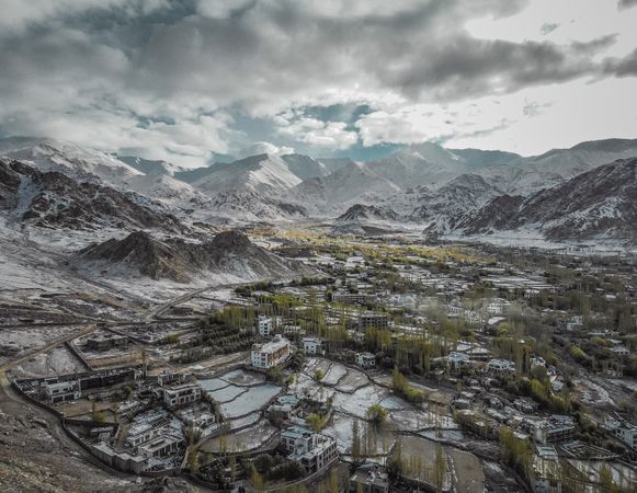 Drone Photography Of Snow Covered Mountain And Rural Town Under Cloudy Sky Photo