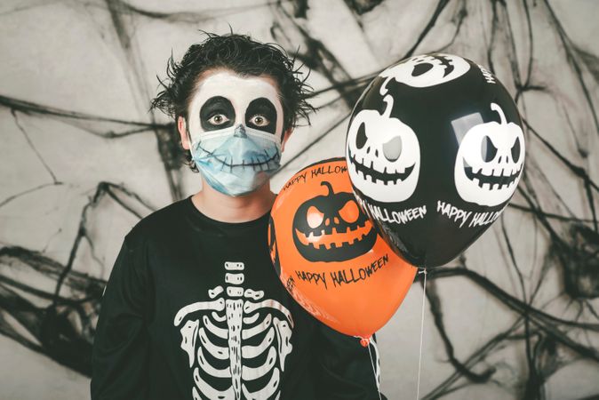 Premium Happy Halloween Kid Wearing Medical Mask In A Skeleton Costume With Halloween Pumpkin Over On His Head Over Gray Background Photo Download In Png Jpg Format