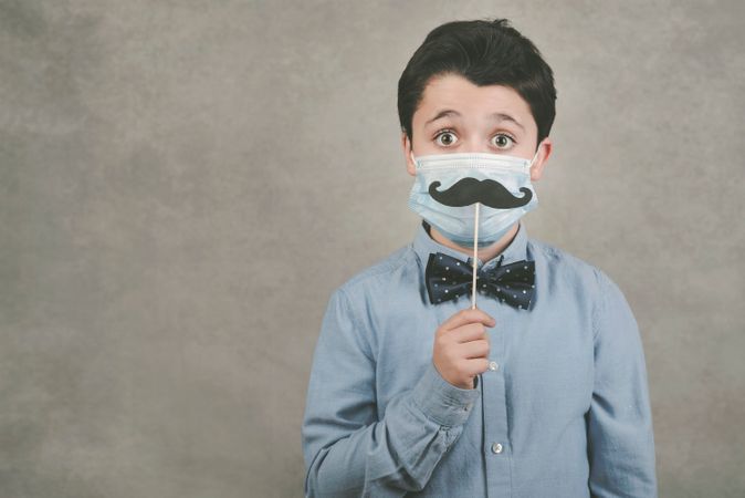 Download Premium Kid Wearing Medical Mask And Smile False On Stick Over Yellow Background Photo Download In Png Jpg Format PSD Mockup Templates