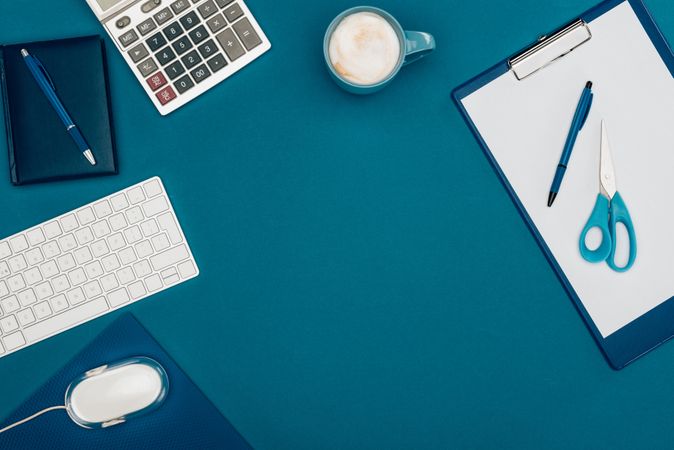 Top View Of Blank Clipboard With Pen And Scissors, Computer Mouse And Keyboard And Calculator On Blue Photo