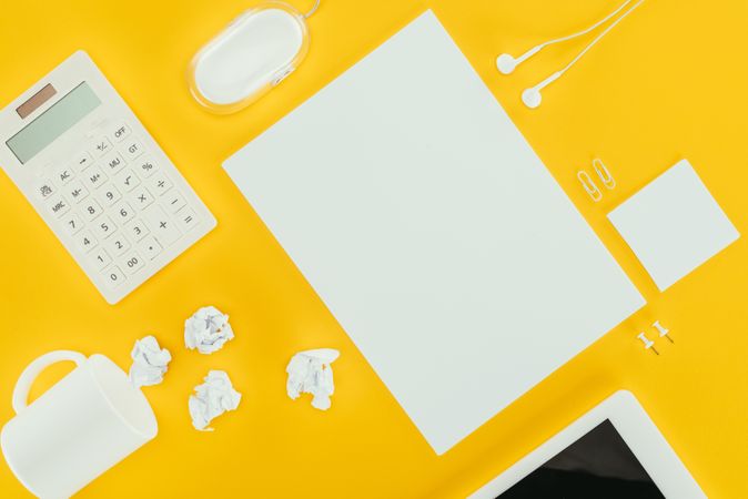 Top View Of Blank Sheet Of Paper, Crumpled Papers, Notes, Calculator And Computer Mouse Isolated On Yellow Photo