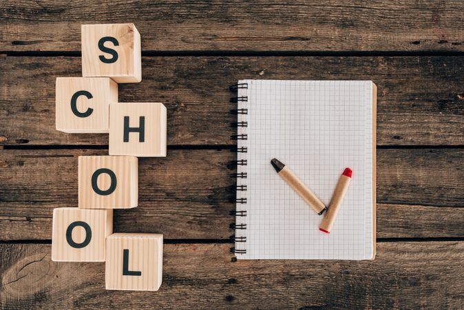 Top View Of Composition Of Colorful Pencils With Blank Notebook And Word School On Wooden Background Photo