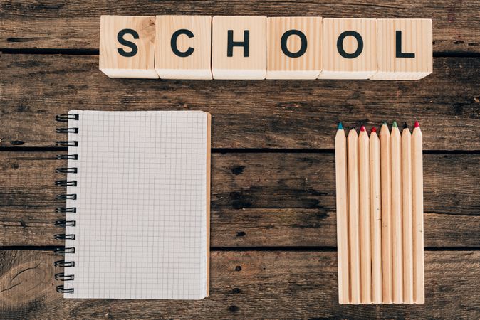 Top View Of Composition Of Colorful Pencils With Blank Notebook And Word School On Wooden Background Photo