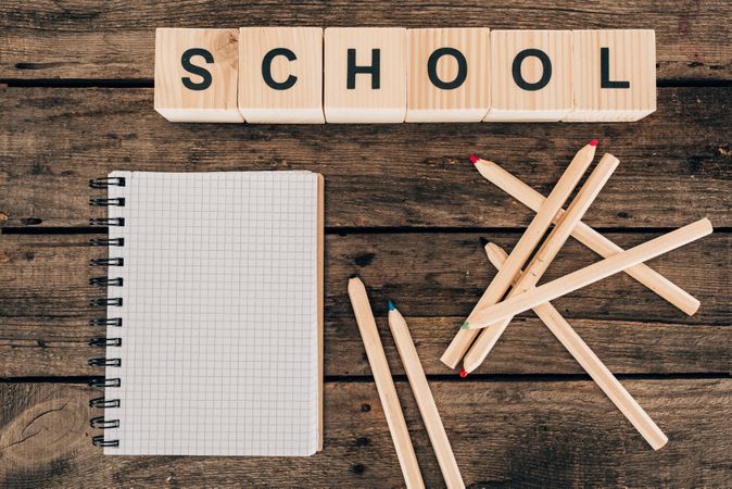 Top View Of Composition Of Colorful Pencils With Blank Notebook And Word School On Wooden Background Photo