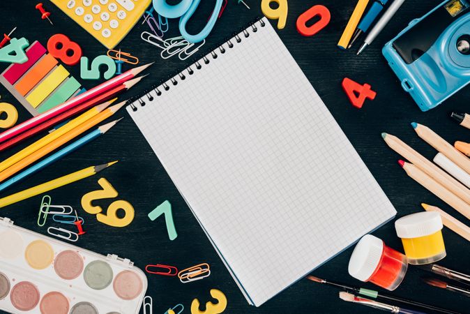 Top View Of Composition Of Colorful School Supplies With Blank Notebook Isolated On Dark Board Background Photo