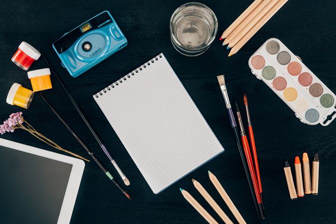 Top View Of Composition Of Colorful School Supplies With Blank Notebook Isolated On Dark Board Background Photo