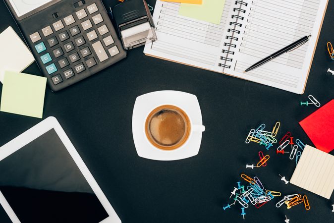 Top View Of Digital Tablet With Blank Screen, Cup Of Coffee, Calculator And Office Supplies On Black Photo