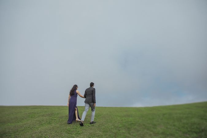 Young Couple Walking On Wide Green Field With Holding Hands Photo